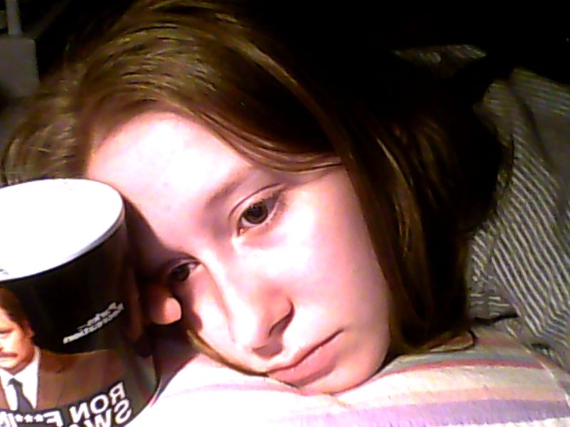 decrepit girl lying down, holding a ron swanson mug, and staring into the void